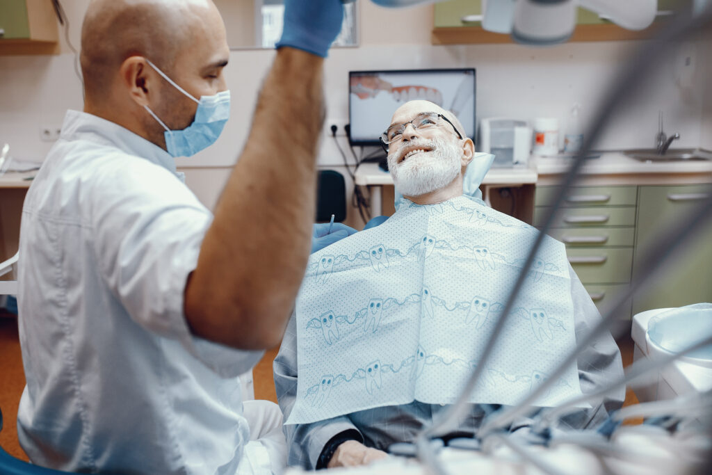 old man sitting on dental chair having a dental checkup with the doctor.